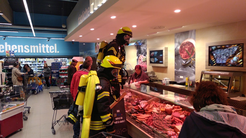 Erstaunte Blicke der Kunden, aber die Atemschutzträger der Feuerwehr klären gleich auf, dass es sich um eine Übung handelt.