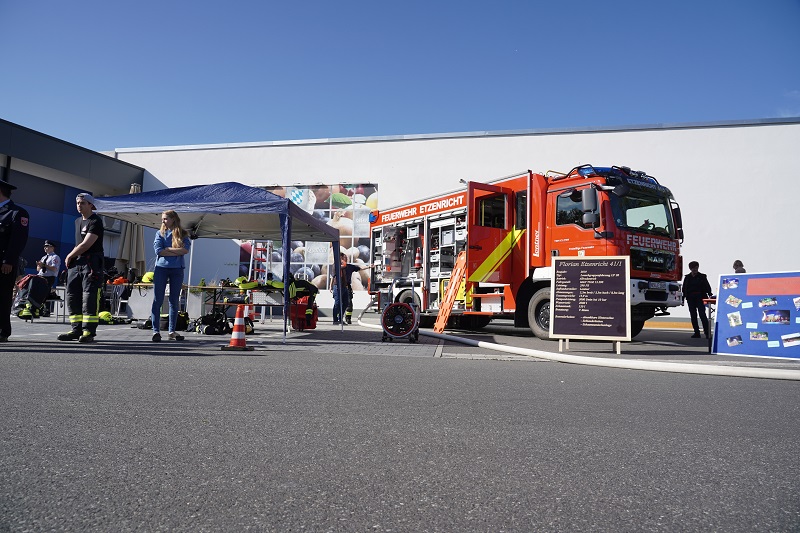 Kinder und Erwachsene sind begeistert und zeigen sich interessiert an der Präsentation und an Informationen über die Feuerwehr.